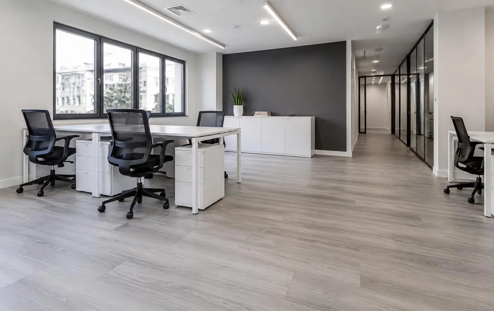 Piso laminado de réguas largas tom cinza claro em sala comercial em Jaú